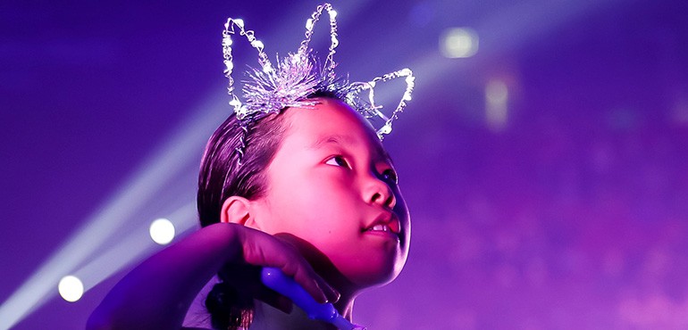 young students performing at School Spectacular with purlpe background